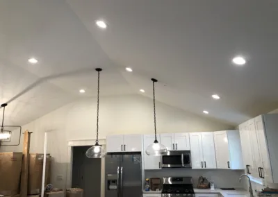 A kitchen with white cabinets and ceiling lights.